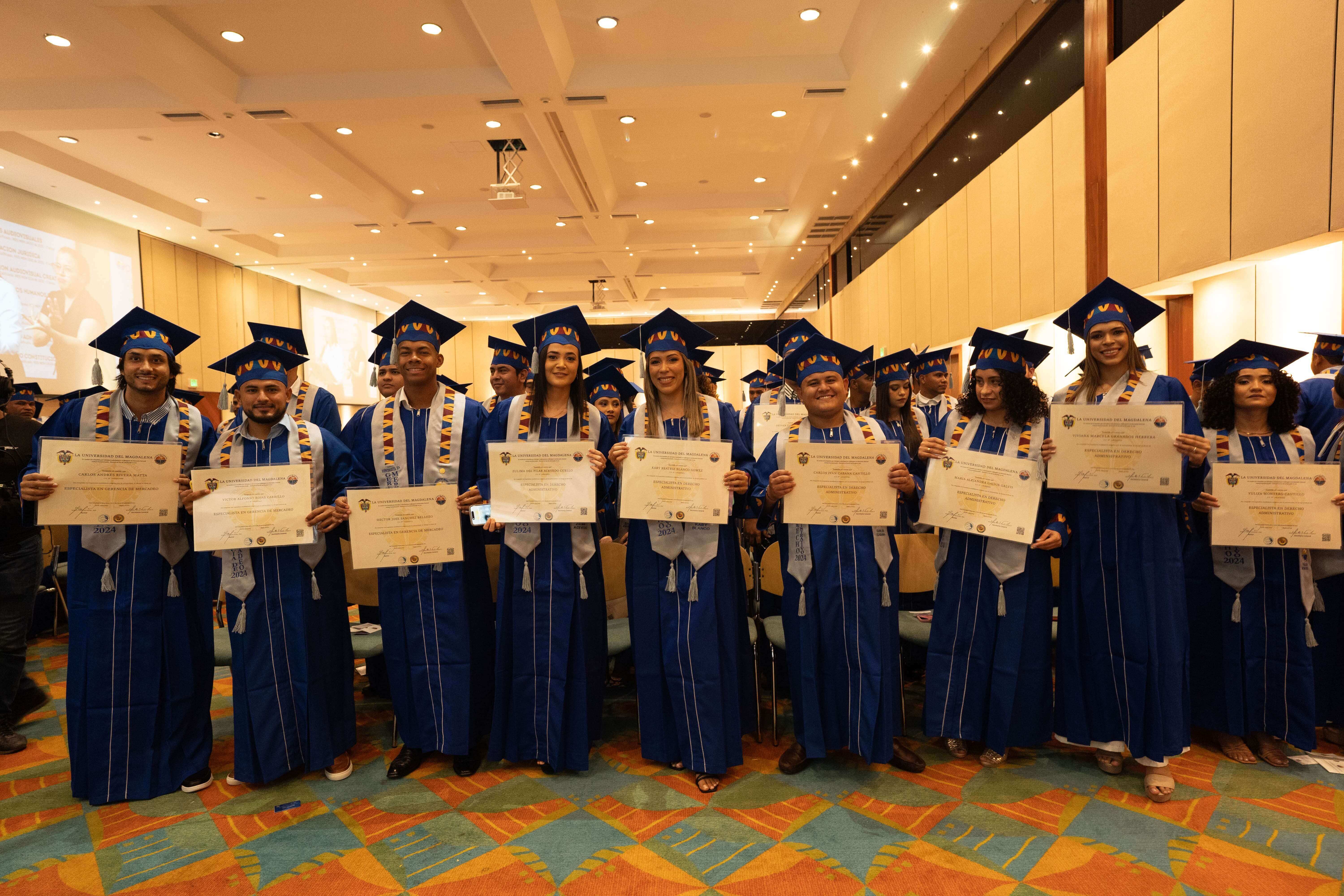 Graduados felices al recibir sus títulos de posgrado.