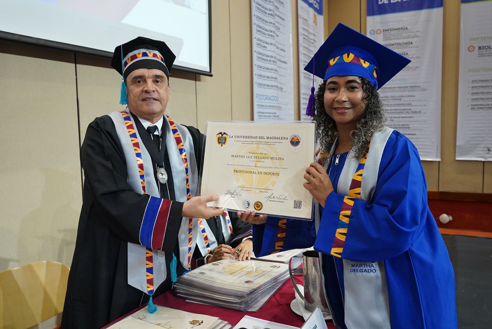 El doctor Óscar García Vargas, Vicerrector Académico, entrega el diploma a Martha Delgado Molina como Profesional en Deportes