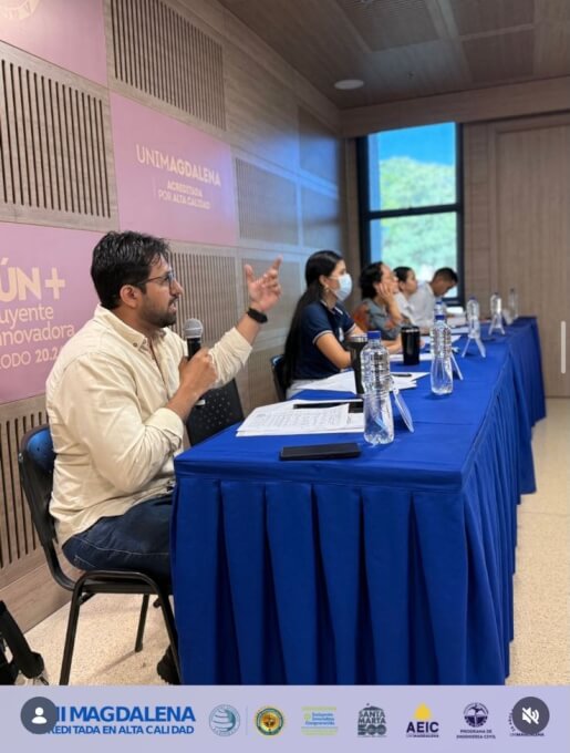 Imagen de socialización académica en la Universidad del Magdalena, donde estudiantes presentan proyectos de ingeniería civil ante un panel de jurados en un aula, con mesas organizadas y participación activa de evaluadores.